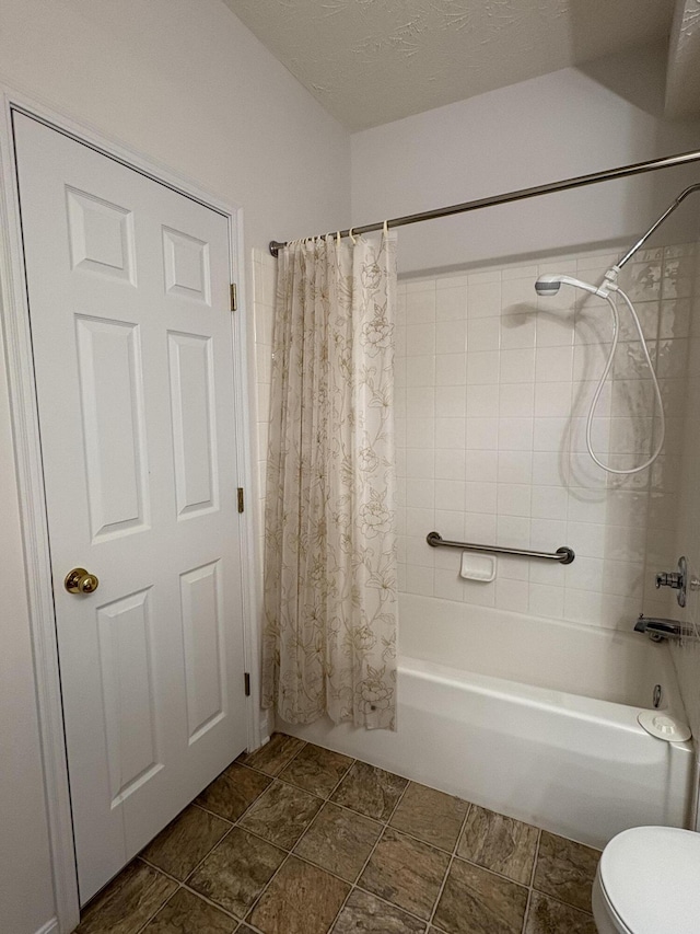 bathroom featuring a textured ceiling, shower / tub combo, and toilet