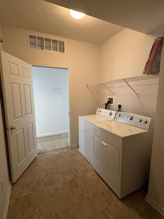 laundry area featuring dark tile patterned flooring, independent washer and dryer, and a textured ceiling