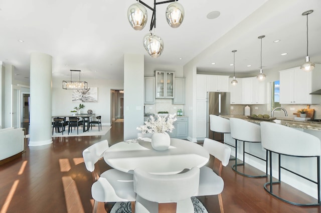 dining area with dark hardwood / wood-style flooring and an inviting chandelier