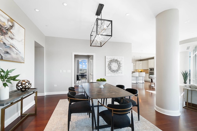 dining room featuring ornate columns and dark hardwood / wood-style flooring