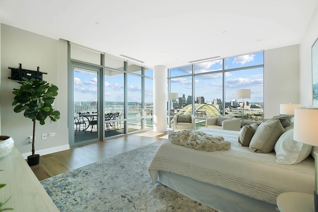 bedroom featuring expansive windows, wood-type flooring, and access to outside