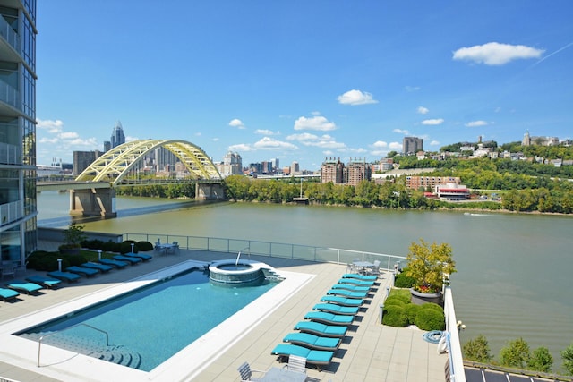 view of swimming pool featuring a patio area and a water view