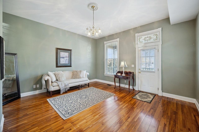 living room with hardwood / wood-style floors and an inviting chandelier