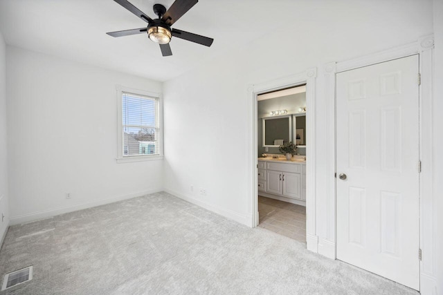 unfurnished bedroom featuring connected bathroom, ceiling fan, and light carpet