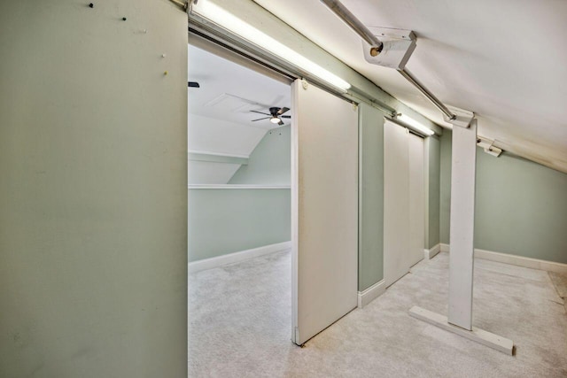 hallway with light colored carpet and vaulted ceiling