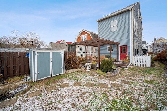 back of house with a storage shed, a pergola, and a deck