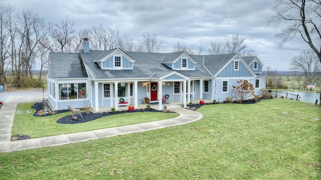 cape cod-style house featuring a front yard and a porch