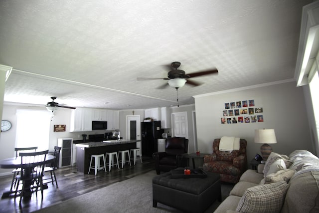 living room with crown molding, ceiling fan, dark hardwood / wood-style flooring, and a textured ceiling