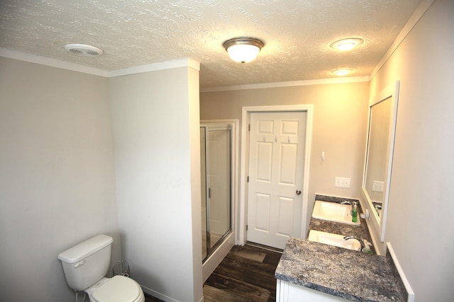 bathroom with hardwood / wood-style floors, vanity, toilet, a shower with door, and crown molding