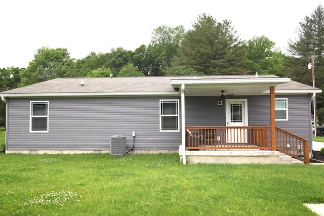 rear view of property featuring a yard and central AC