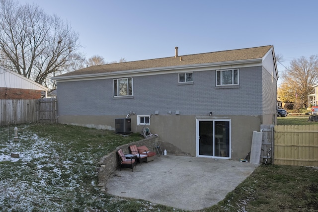 rear view of property with a patio area, a yard, and central AC