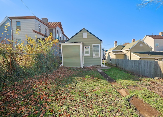 rear view of property featuring a lawn