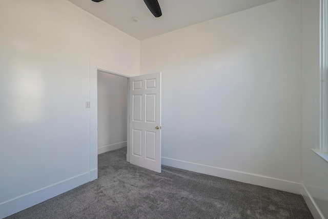 empty room featuring dark colored carpet and ceiling fan