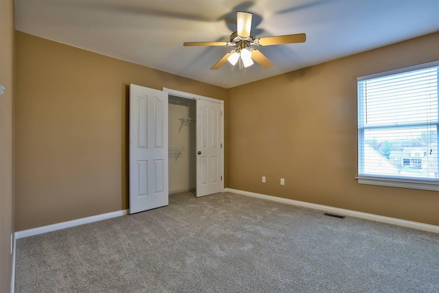 unfurnished bedroom featuring ceiling fan, a closet, and light carpet