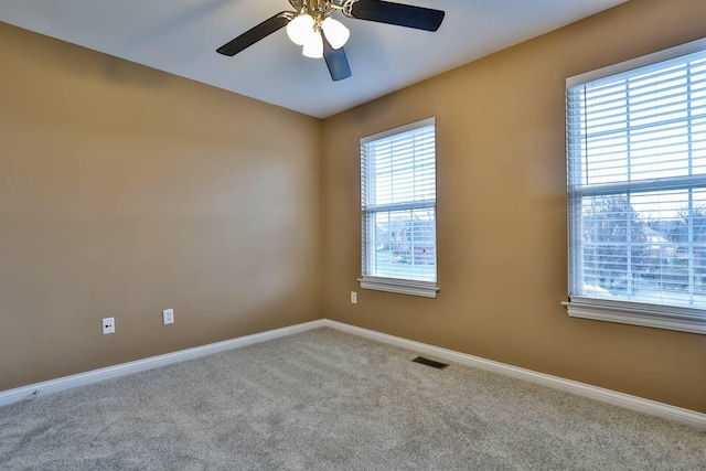 unfurnished room with carpet flooring, a wealth of natural light, and ceiling fan