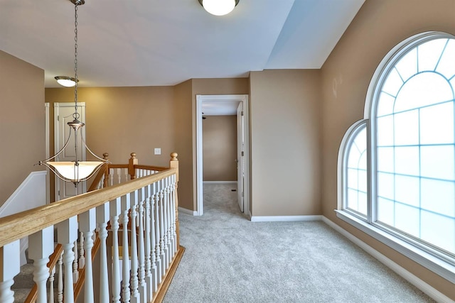 corridor with carpet and a healthy amount of sunlight