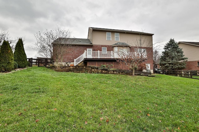 rear view of property with a yard and a wooden deck