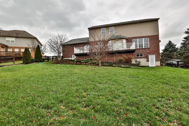 back of property with a lawn and a wooden deck