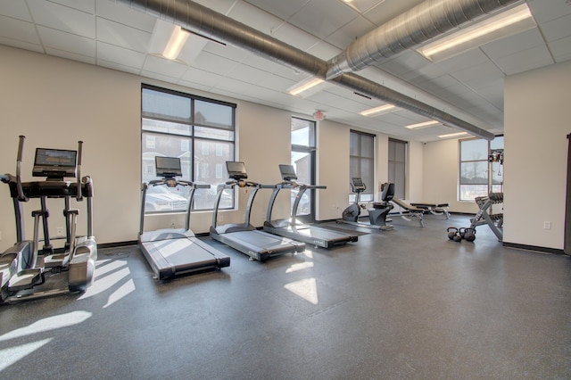 workout area featuring a drop ceiling and a wealth of natural light