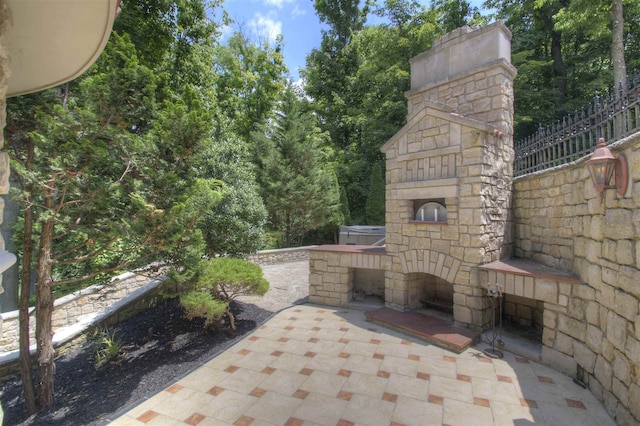 view of patio / terrace featuring an outdoor stone fireplace