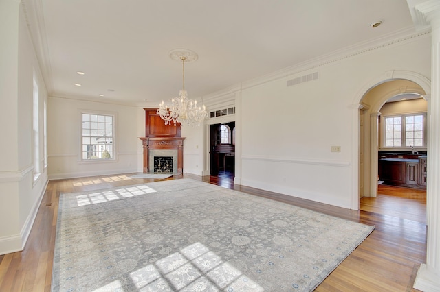 unfurnished living room with a chandelier, visible vents, and light wood-style flooring