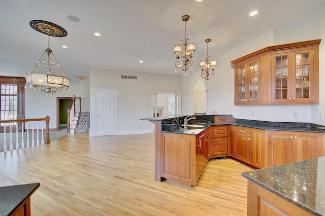 kitchen with a sink, visible vents, light wood-style floors, and a chandelier