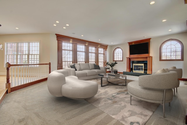 living area featuring light carpet, recessed lighting, a fireplace, and baseboards