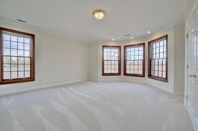 unfurnished room featuring baseboards, light carpet, a healthy amount of sunlight, and ornamental molding