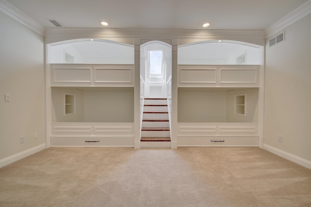 interior space featuring visible vents, ornamental molding, and carpet flooring