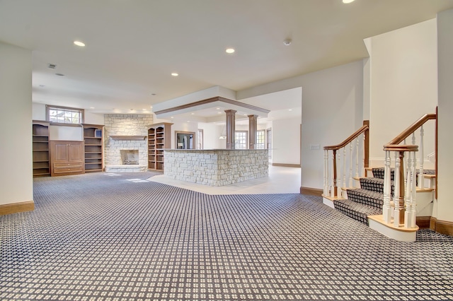 unfurnished living room with stairway, carpet, baseboards, a fireplace, and recessed lighting