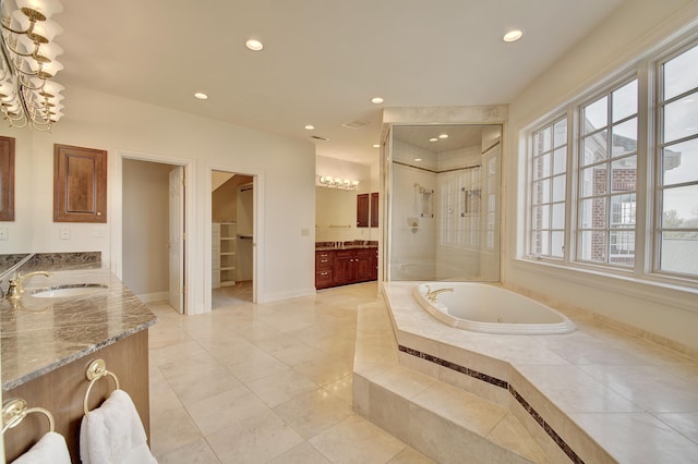 bathroom featuring two vanities, recessed lighting, a stall shower, a sink, and a garden tub