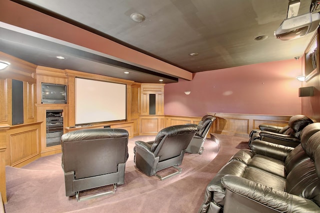 home theater featuring recessed lighting, beamed ceiling, light colored carpet, and a wainscoted wall