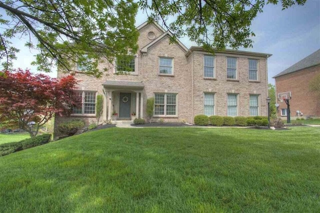 colonial-style house featuring a front lawn