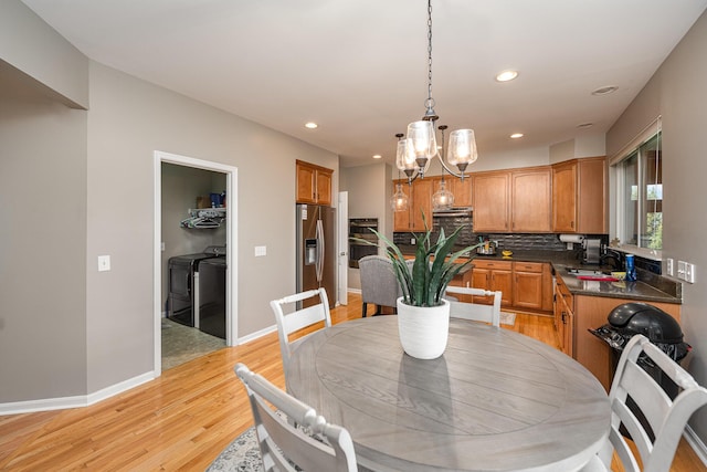 dining room featuring sink, washer and dryer, and light wood-type flooring