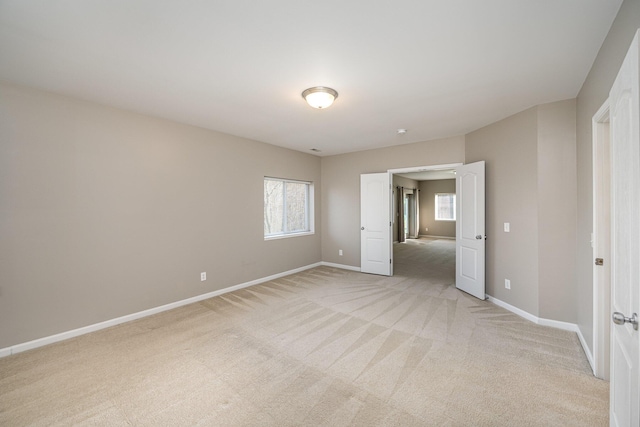 spare room with a healthy amount of sunlight and light carpet