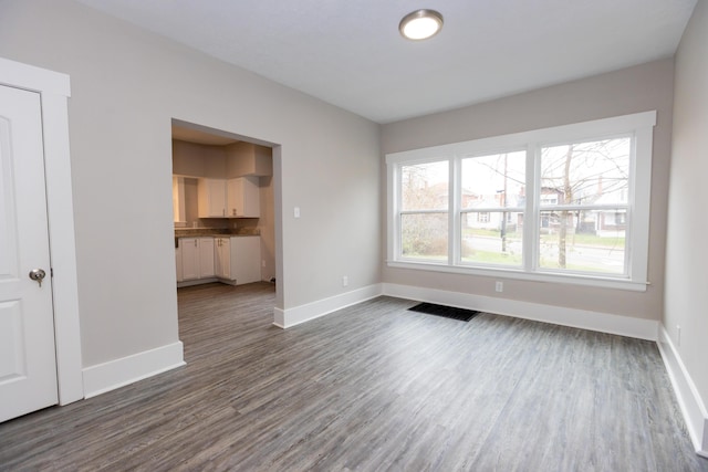 unfurnished living room with dark hardwood / wood-style flooring