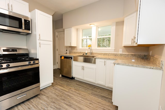 kitchen featuring white cabinets, light wood-type flooring, and stainless steel appliances