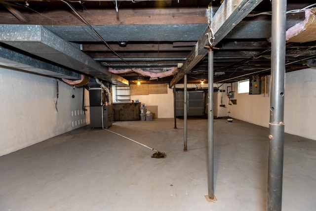 basement featuring electric panel and heating unit