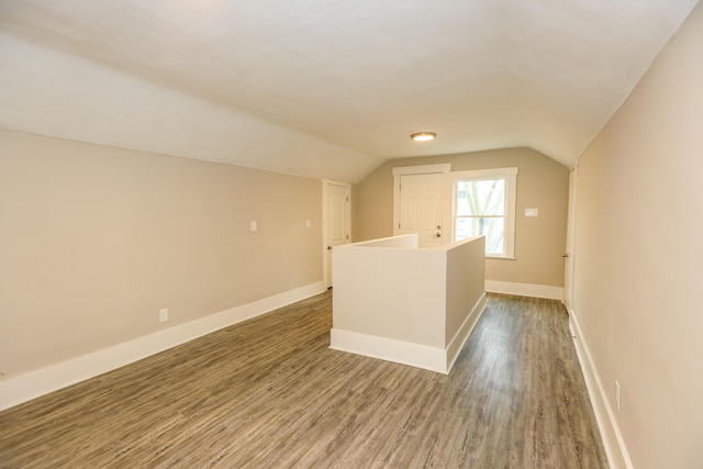 bonus room with hardwood / wood-style floors and vaulted ceiling