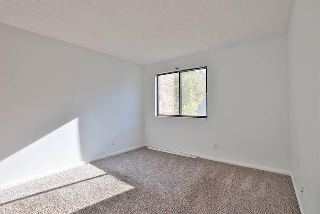 carpeted empty room with a textured ceiling