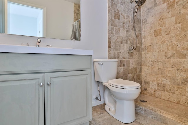 bathroom featuring vanity, toilet, and tiled shower