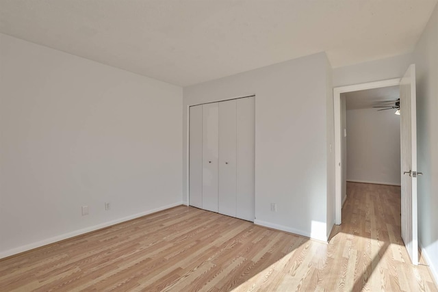 unfurnished bedroom with light wood-type flooring and a closet