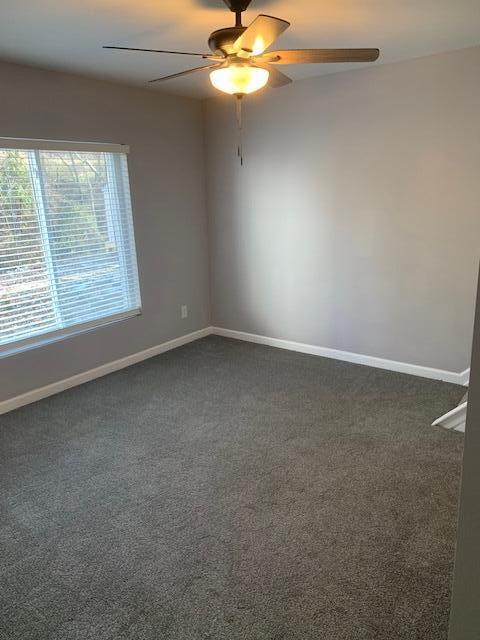 carpeted empty room featuring ceiling fan