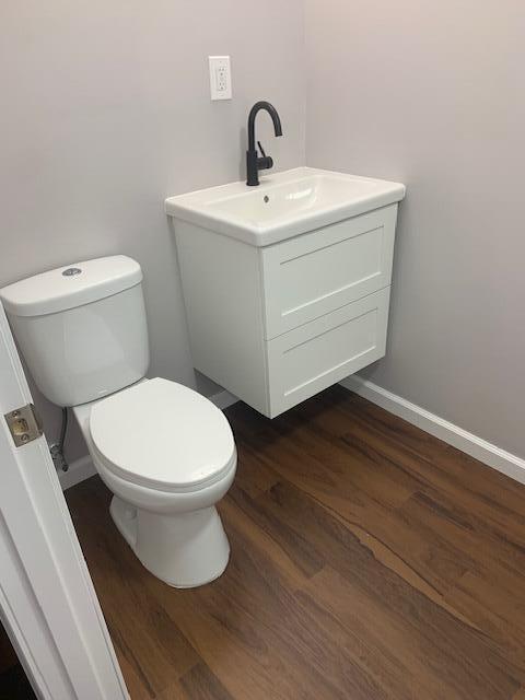 bathroom featuring vanity, hardwood / wood-style flooring, and toilet