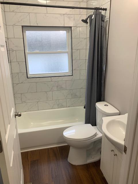 full bathroom featuring toilet, vanity, shower / bath combo, and hardwood / wood-style flooring