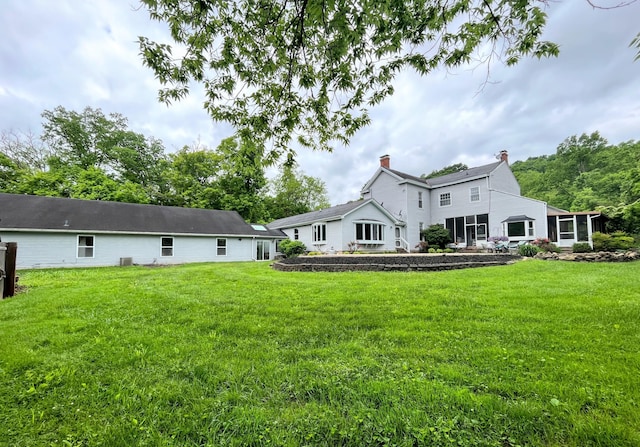 rear view of house featuring a lawn