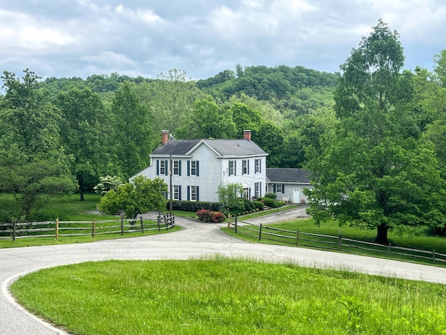 view of front facade with a rural view and a front yard