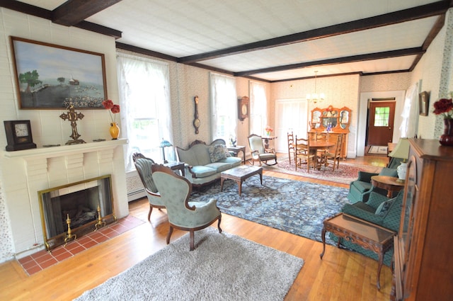 living room featuring a baseboard heating unit, beamed ceiling, a notable chandelier, wood-type flooring, and a tiled fireplace