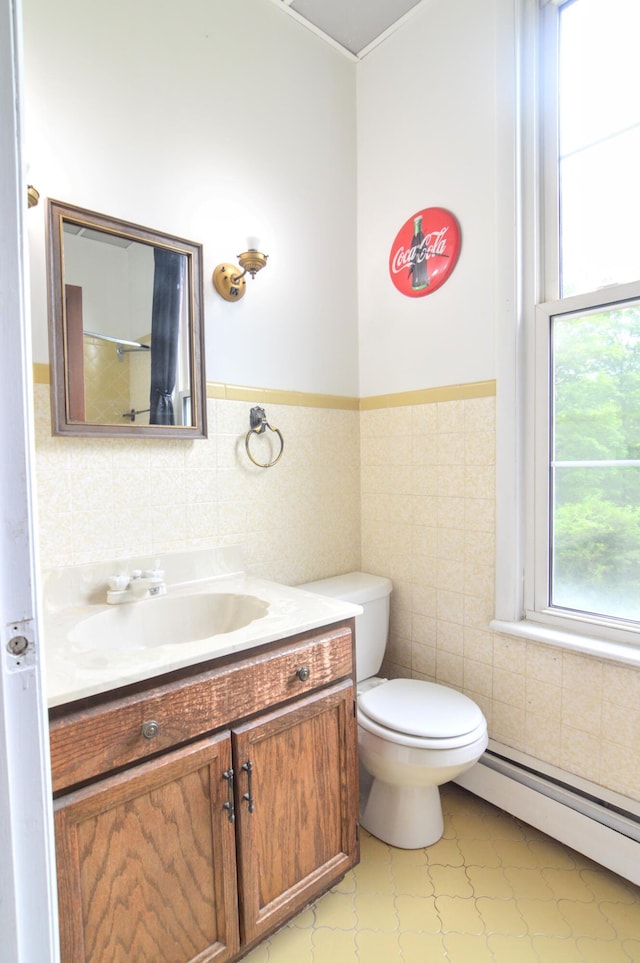 bathroom featuring vanity, a baseboard radiator, tile walls, and toilet