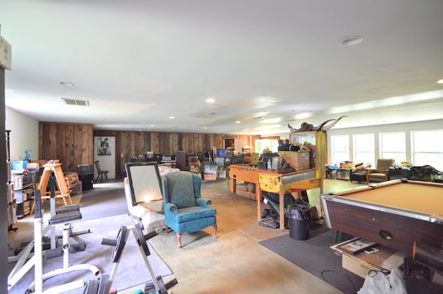 recreation room with wood walls and billiards